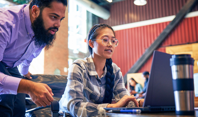 a man sitting at a table using a laptop