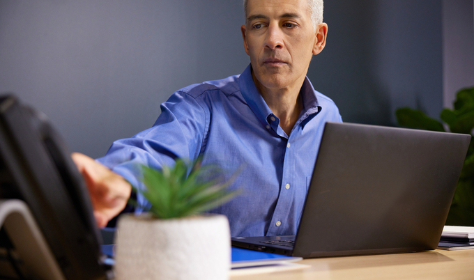 a man sitting at a table using a laptop computer