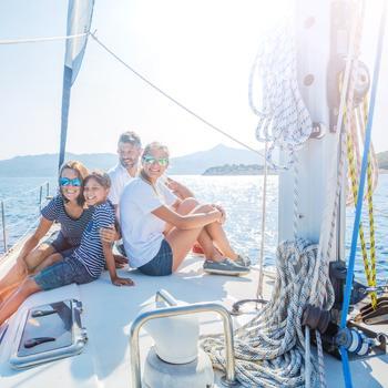 Family on sailboat on open water.