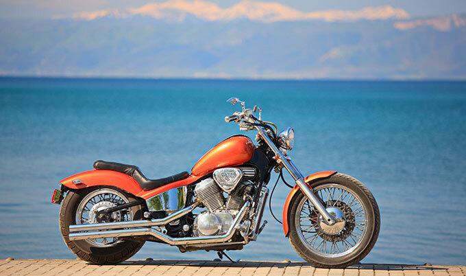 orange motorcycle by water