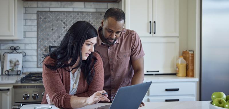 couple looking at computer in the kitchen 