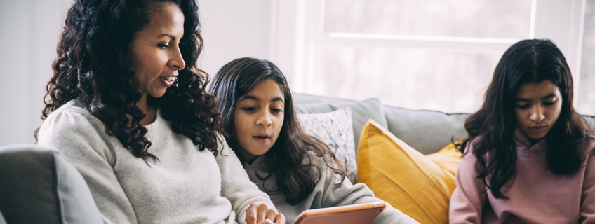 mom and daughters on tablet