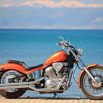 orange motorcycle by water