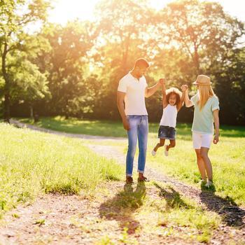 Mother and father swing their daughter.
