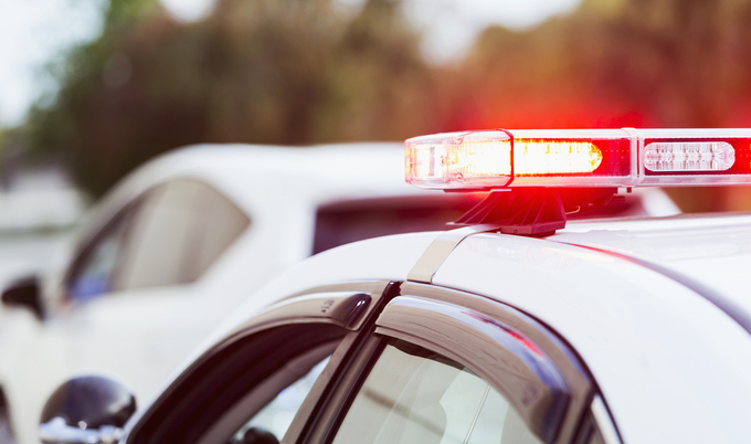 Police car with lights flashing making traffic stop