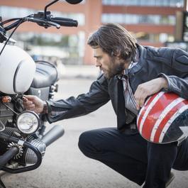 Bearded man looking at used motorcycle. 