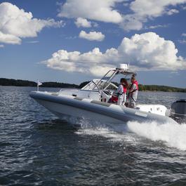 Man and woman driving motorboat on lake.