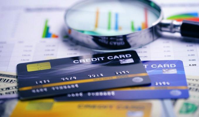 Credit cards and magnifying glass on papers.