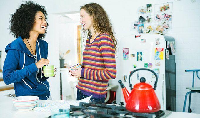 two women laugh in kitchen