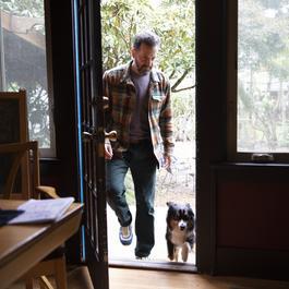 man with dog entering home