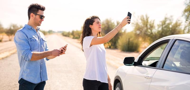 Couple with broken car searching for phone coverage