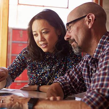 Couple looking at something on a laptop.