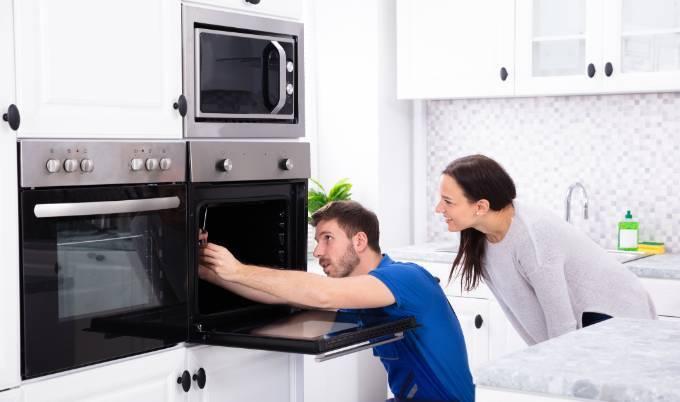 Man and woman looking inside oven