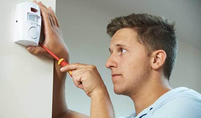 man installing burglar alarm