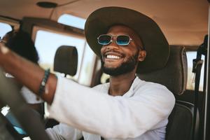 Smiling man wearing sunglasses driving on a summer vacation