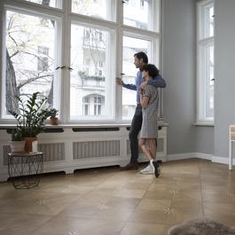 Couple looking out their condo window. 