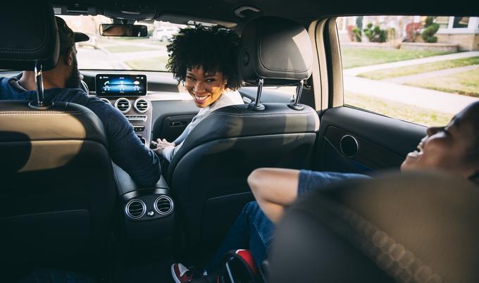 Man and woman in car looking at kid in backseat