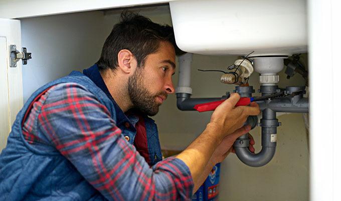 man fixing sink