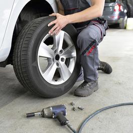Closeup of a mechanic changing a car tire.  