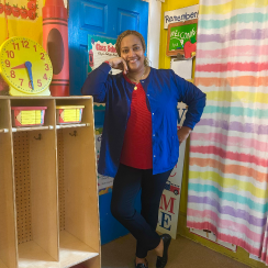 Woman standing in classroom next to cubbies at Lloyd’s Lollipop Land Daycare.