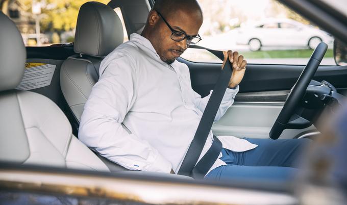 man putting on seatbelt