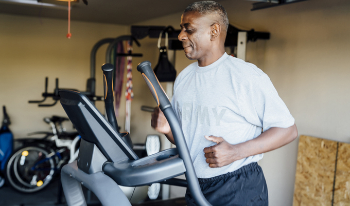 A man using exercise equipment in the garage.
