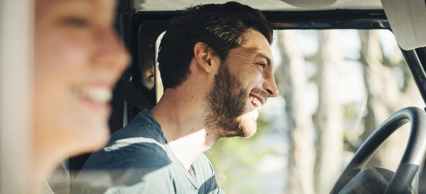 Side view of happy couple enjoying road trip