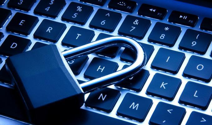 Close-up of laptop keyboard with  a lock laying on top.