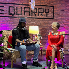 A woman and man sitting in front of microphones talking at The Quarry. 
