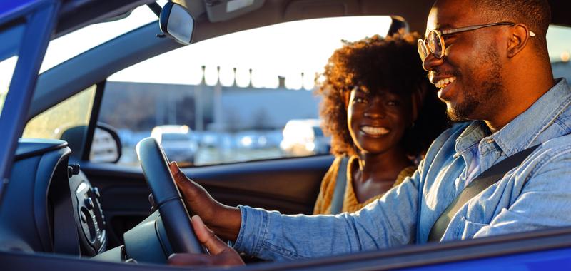Cheerful couple enjoying a ride in their car