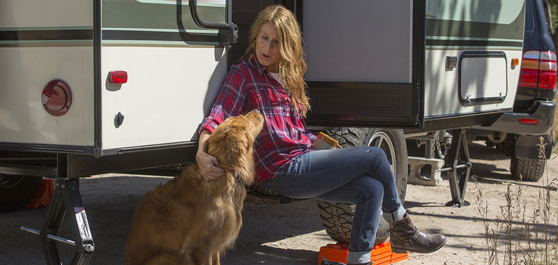 Woman petting dog next to trailer