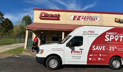 Two agents outside of a Direct Auto location with the Direct On the Spot Van.
