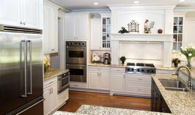Kitchen with granite counterops white cabinets.