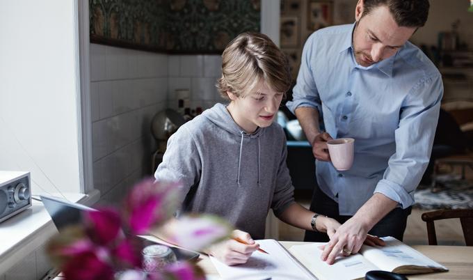 Dad is helping son with homework.