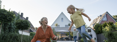 Happy woman with daughter and son enjoying their backyard