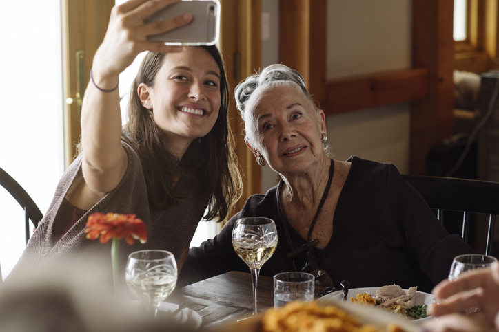 Two women taking a selfie at table