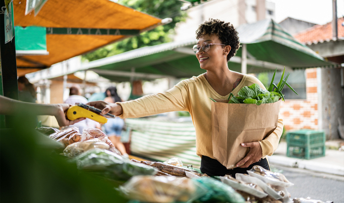 Young woman shopping for groceries at a sidewalk market