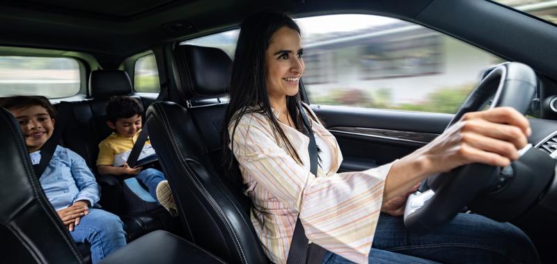 Mom driving with her two kids in the backseat