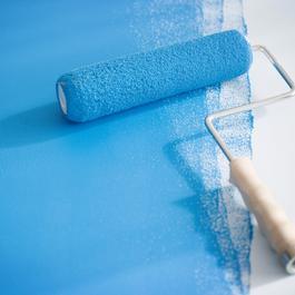 Paint roller on partially painted floor