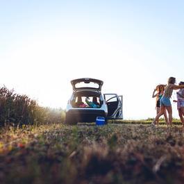 Cheerful girls taking a break at sunset while traveling to the beach