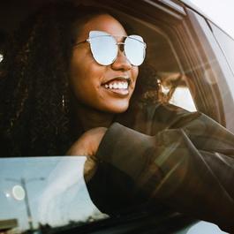 Group of young adults having fun riding in car.