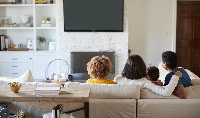 Family sitting on a couch in a living room.