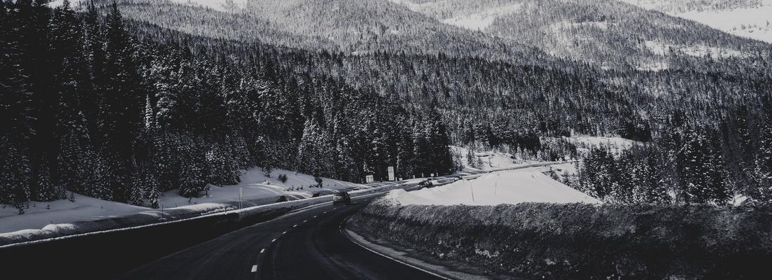 A road next to a snow covered mountain range