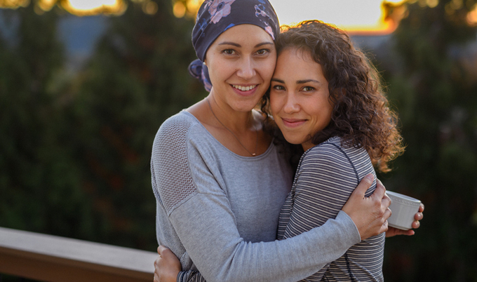 Woman going through cancer embracing a friend.