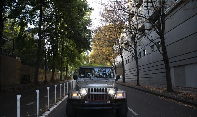jeep with headlights driving by divider