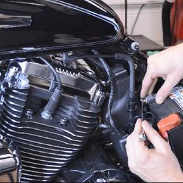 Hands changing out a motocycle battery.