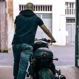 man pushing motorcycle