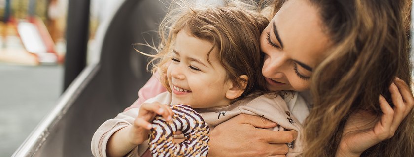 Mother and daughter laughing and having fun on playground