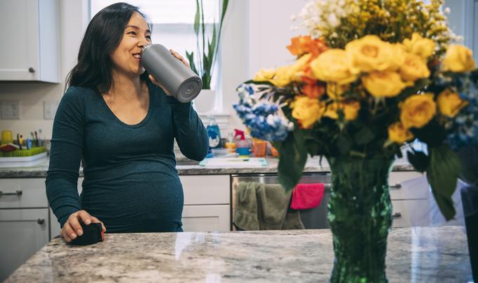 woman drinking water in kitchen