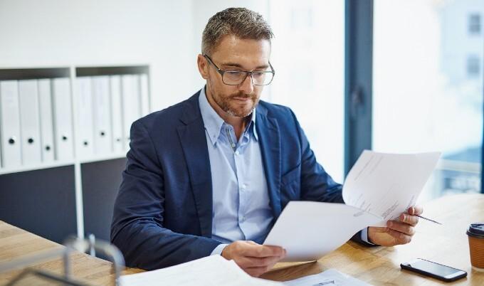 Man reading paperwork in office